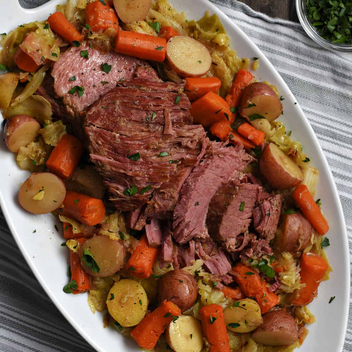 Sliced corned beef, cabbage, red potatoes and carrots on a large platter.