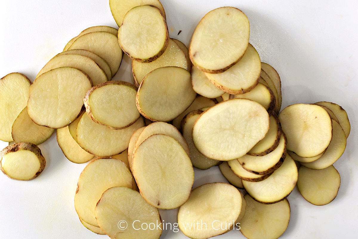 Potato slices on a cutting board. 