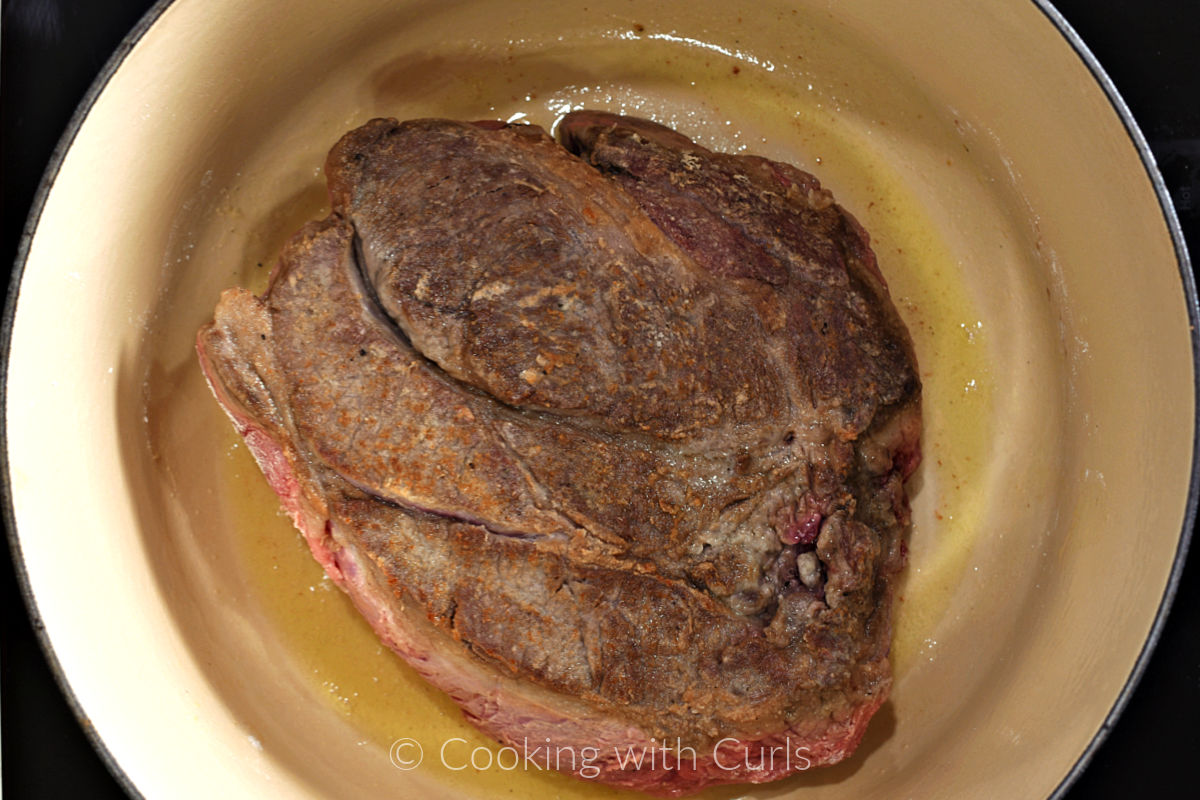Seared beef chuck roast in a Dutch oven. 