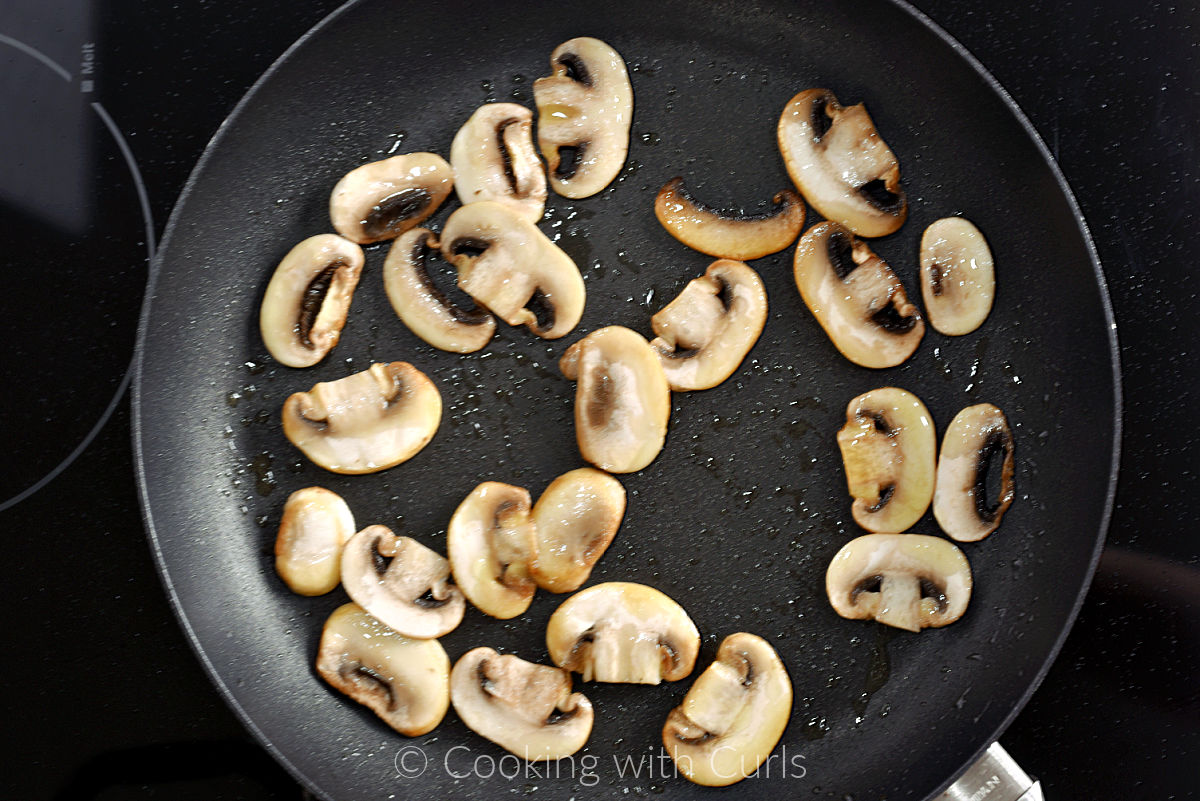 Sliced mushrooms and oil in a non-stick skillet. 