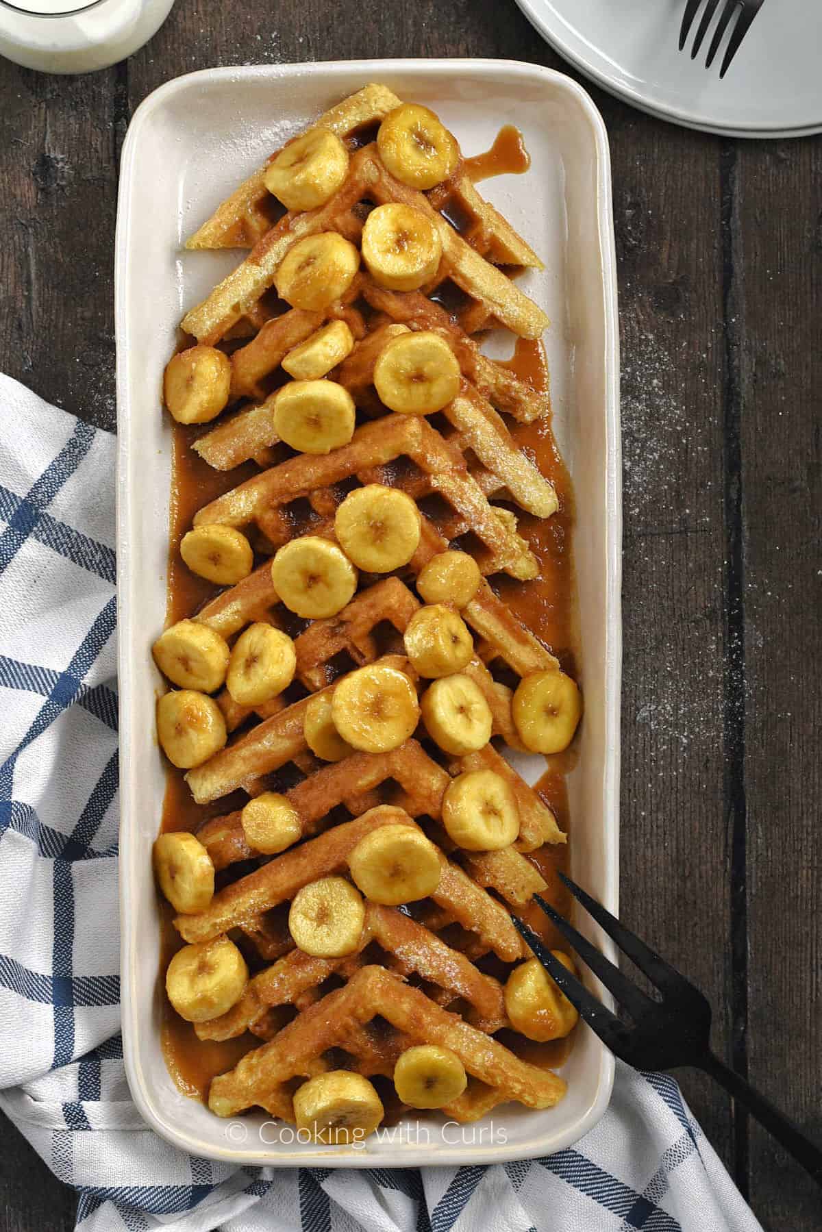 A platter topped with Bananas Foster Belgian Waffles. 