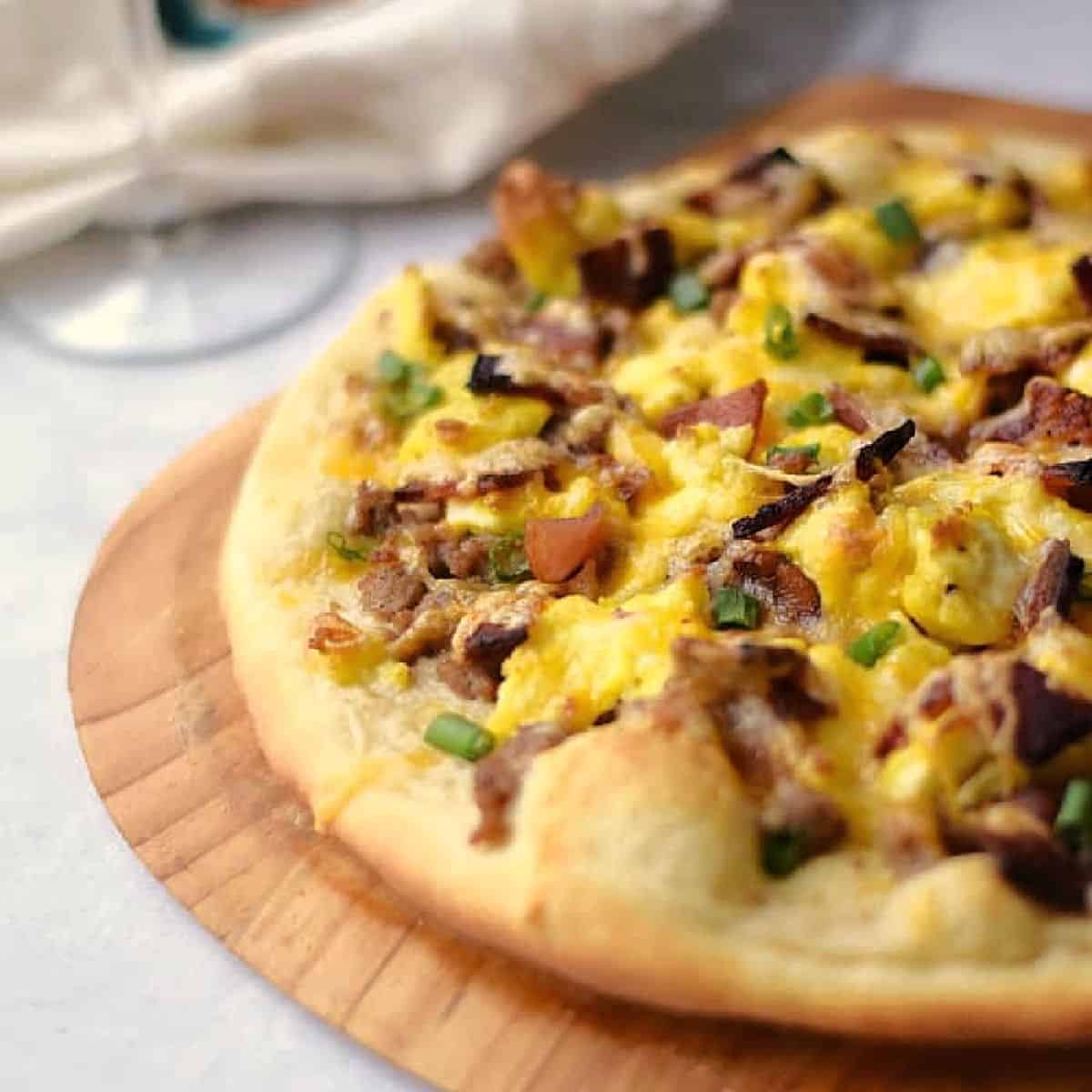 Pizza crust topped with scrambled eggs, bacon, sausage gravy and melted cheese.
