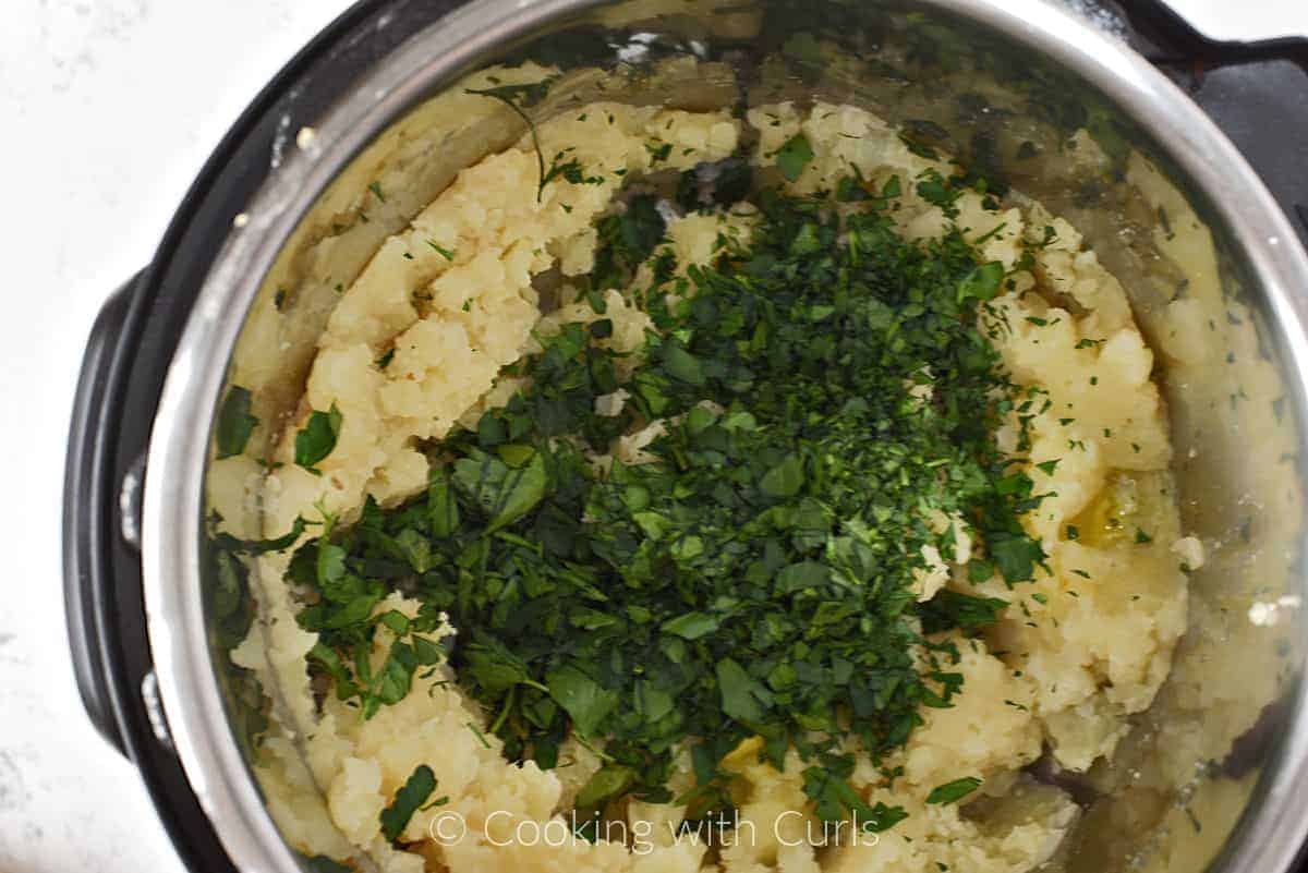 Chopped parsley on top of mashed potatoes in a pressure cooker. 