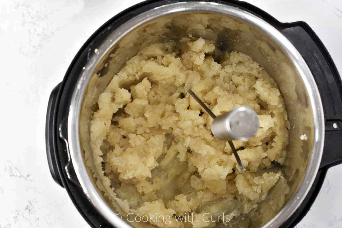 Cooked potatoes mashed in a pressure cooker. 