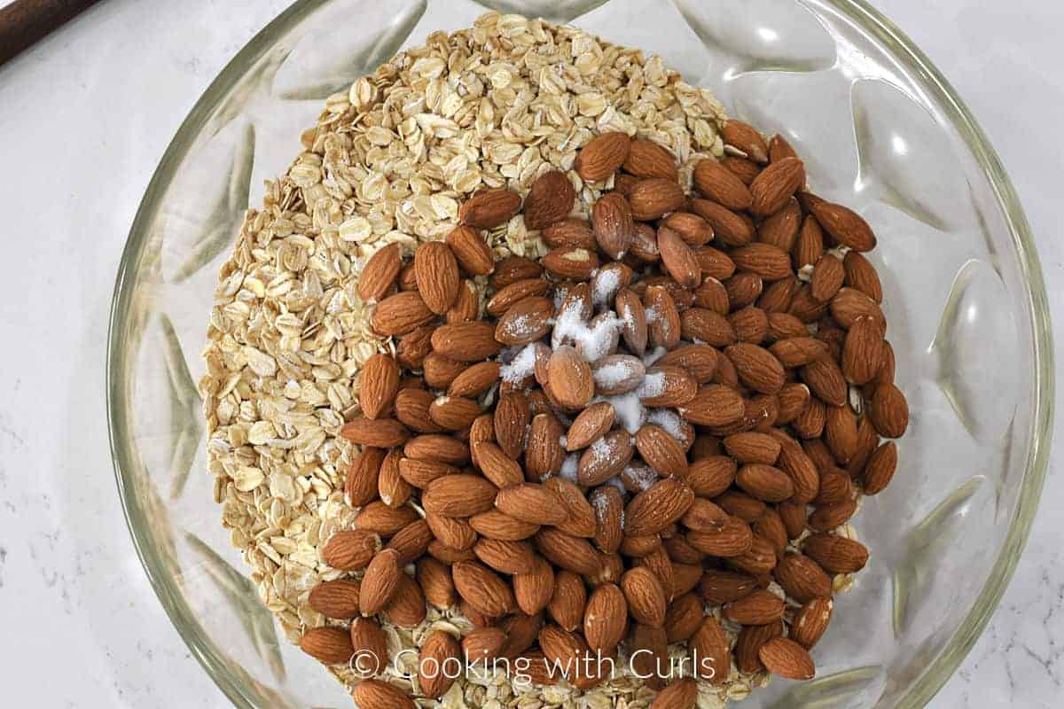 Rolled oats, whole almonds and sea salt in a large bowl. 