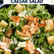 Chopped salmon on top of romaine lettuce, croutons, shaved parmesan and Caesar dressing with title graphic across the top.