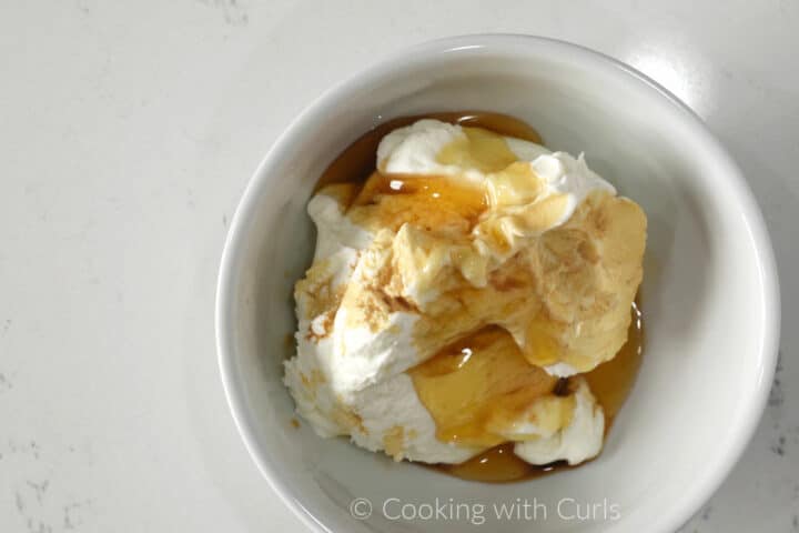 Greek yogurt, honey and vanilla extract in a small bowl.