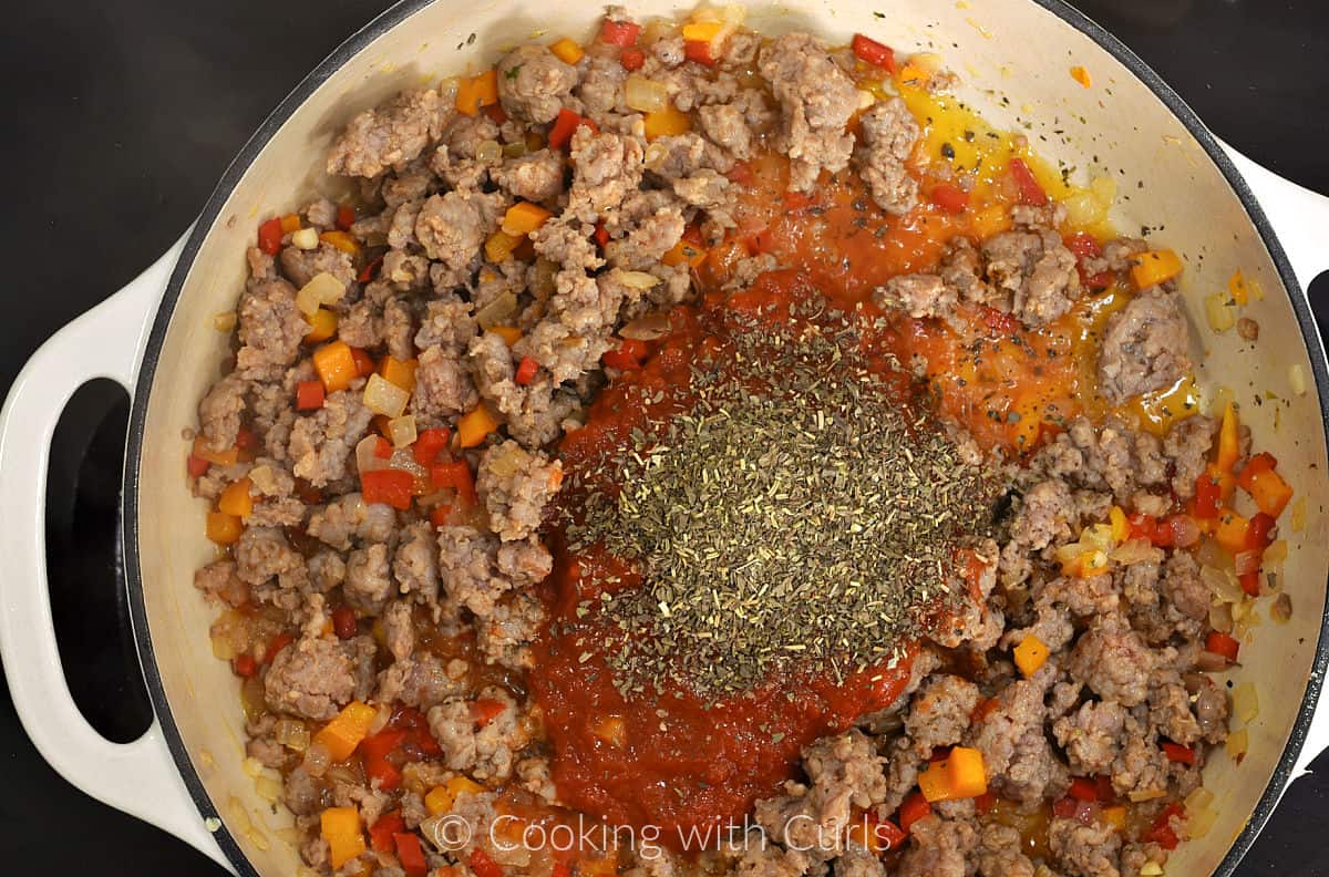 Italian seasoning, pizza sauce, cooked sausage, peppers and onion in a skillet. 