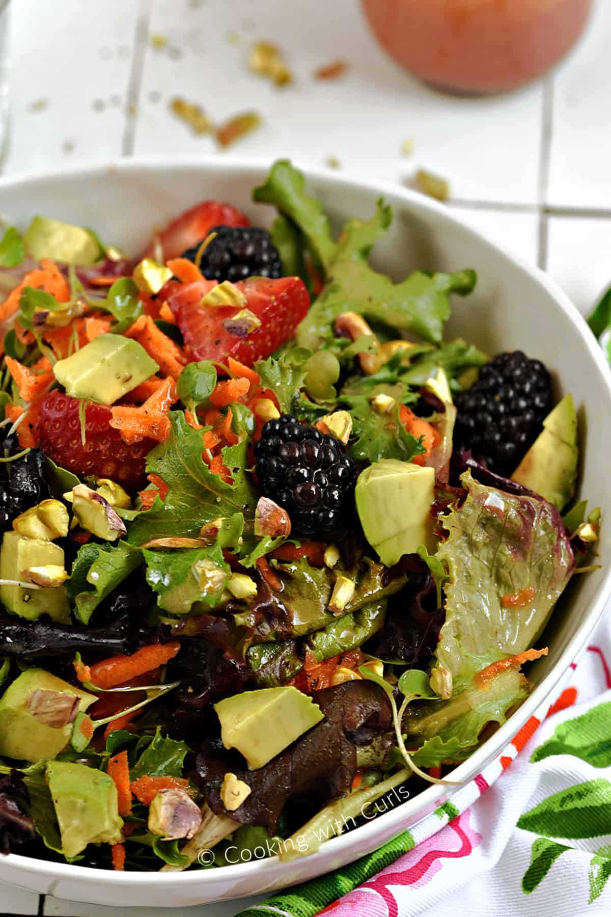A big salad made with mixed greens, berries, avocado, pistachios and micro greens. 