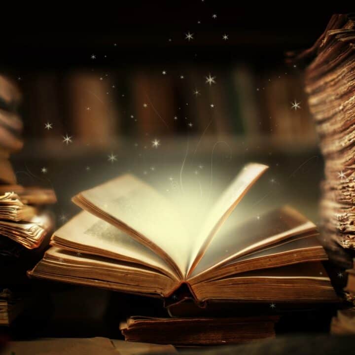 An open book with magical stars swirling out of it.