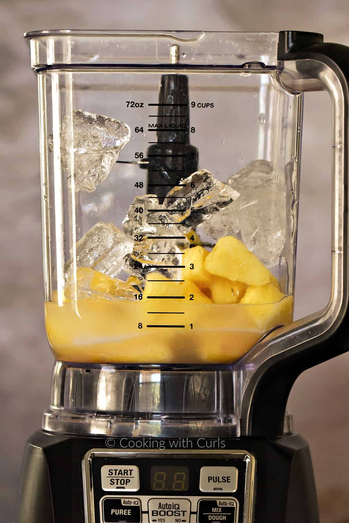 Frozen pineapple chunks, ice cubes, and rum in a blender. 