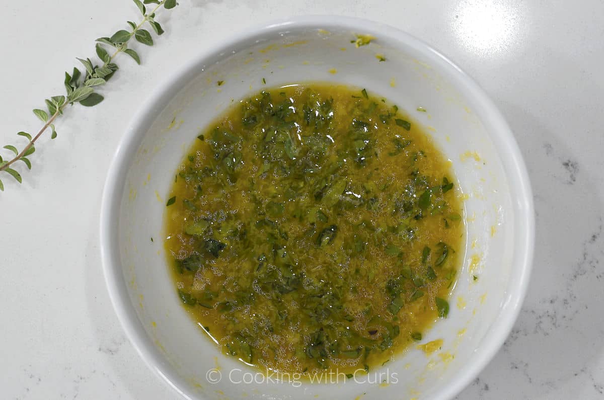 Lemon and herb dressing mixed together in a small bowl. 