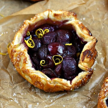 Puff Pastry Cherry Tarts on a sheet of parchment paper.