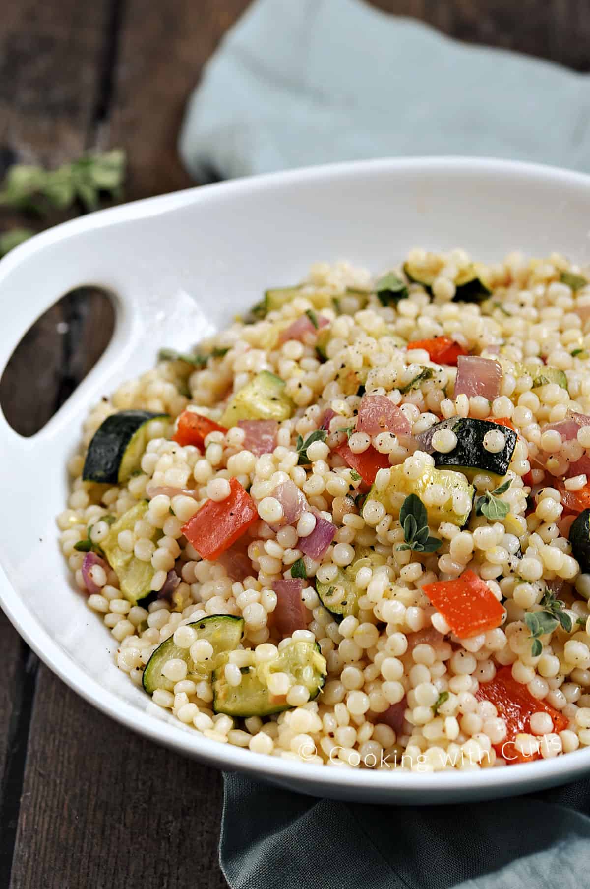 Roasted Vegetable Couscous with zucchini, red pepper, and red onion in a serving bowl. 