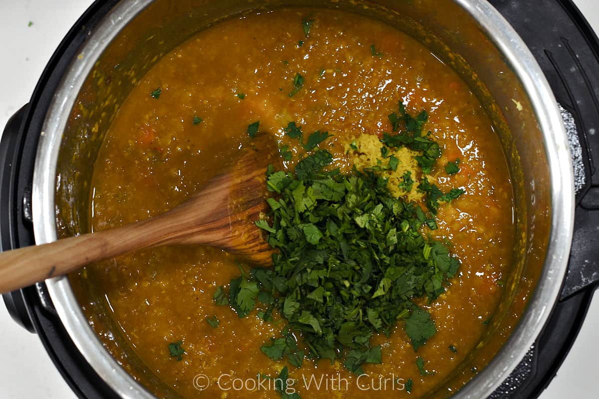A wooden spoon to stir the chopped cilantro and lemon zest into the cooked red lentil soup. 