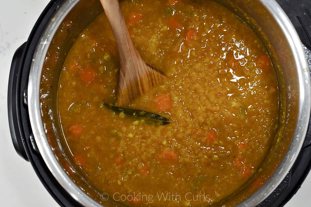 Cooked red lentil soup with a bay leaf in a pressure cooker. 