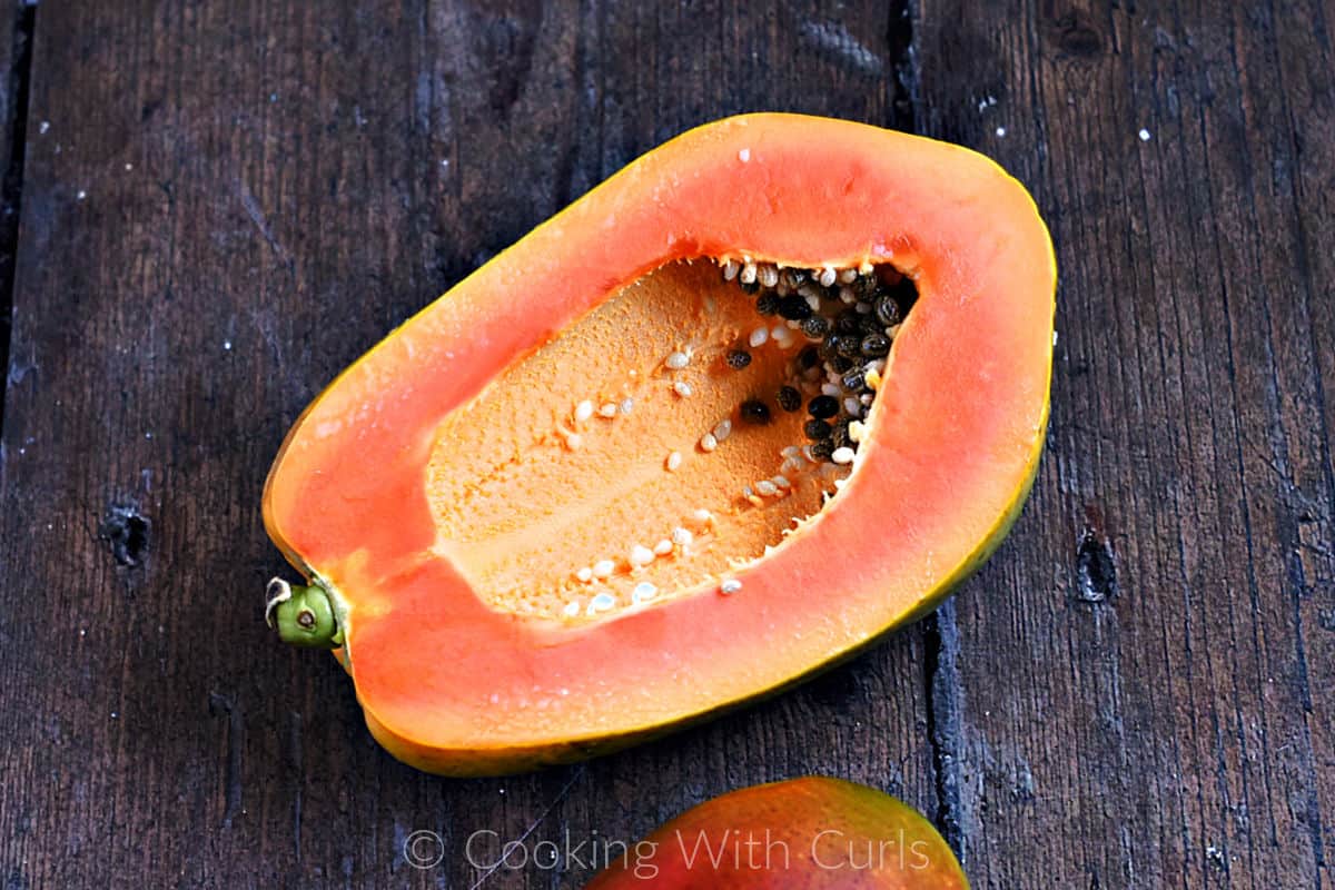 Half of a papaya on a wood background. 