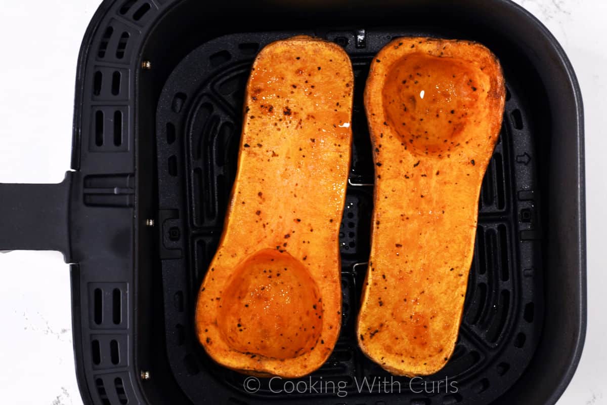 Butternut Squash halves flipped flesh side up in the cooking tray. 