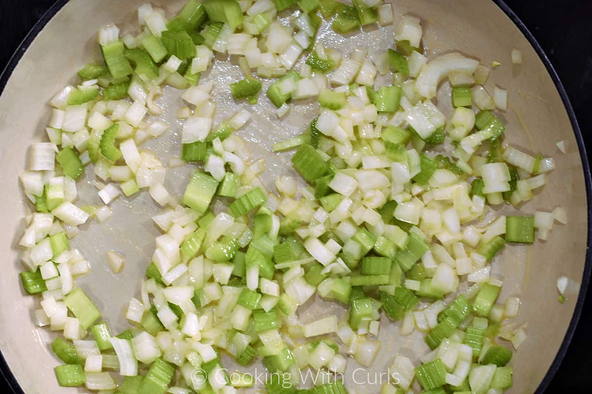Minced onion and celery cooking in a large skillet. 