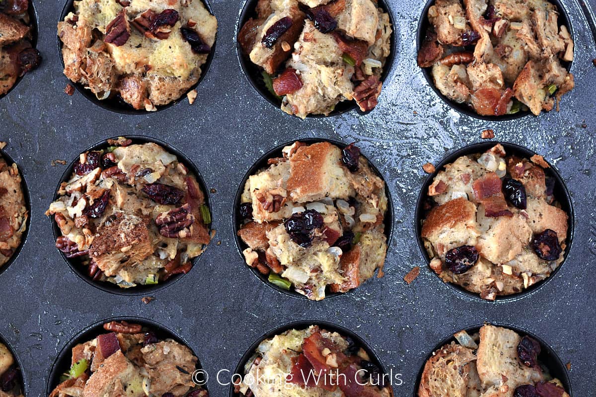 Twelve baked stuffing muffins in the pan. 