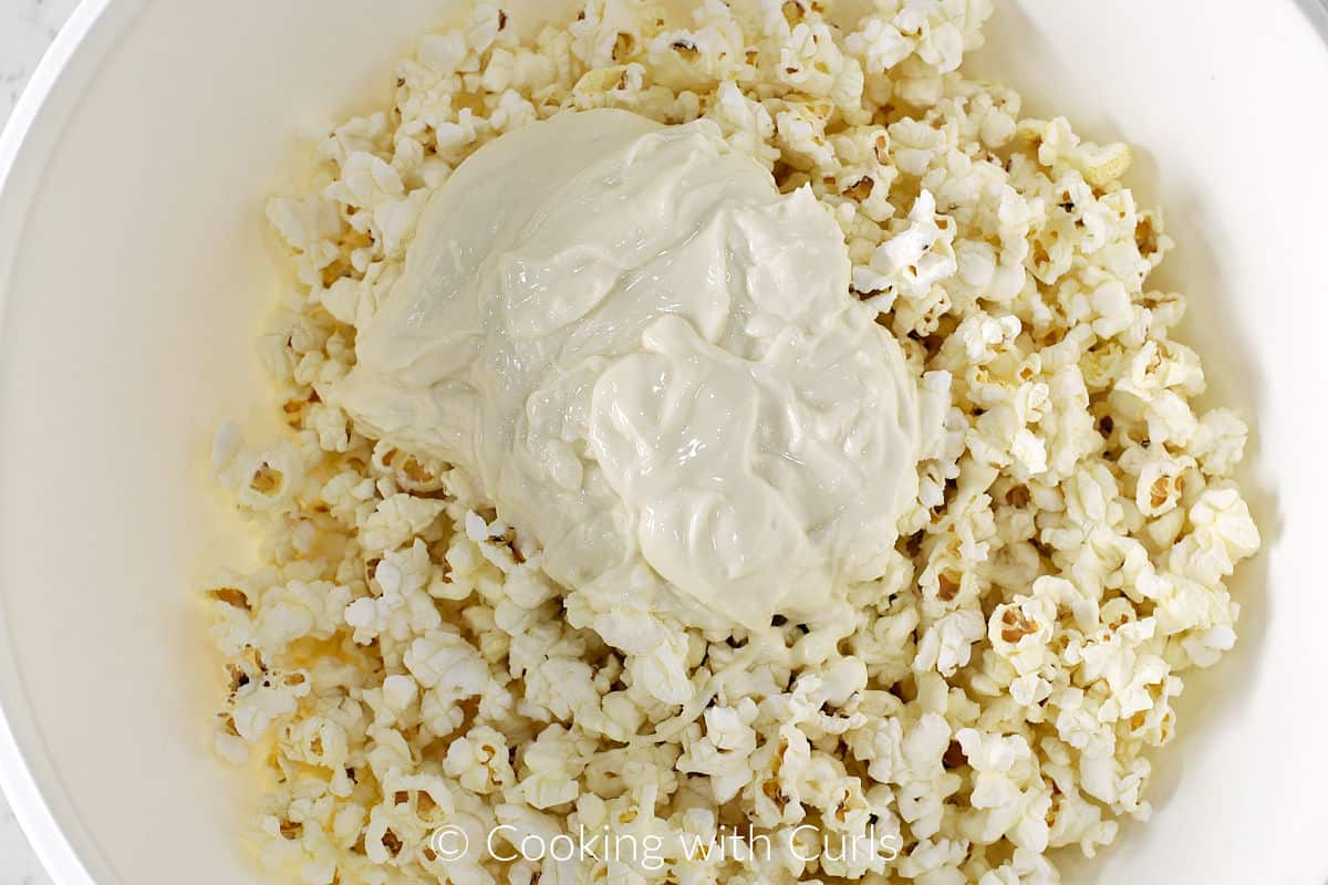 A large bowl with popcorn and melted white chocolate. 