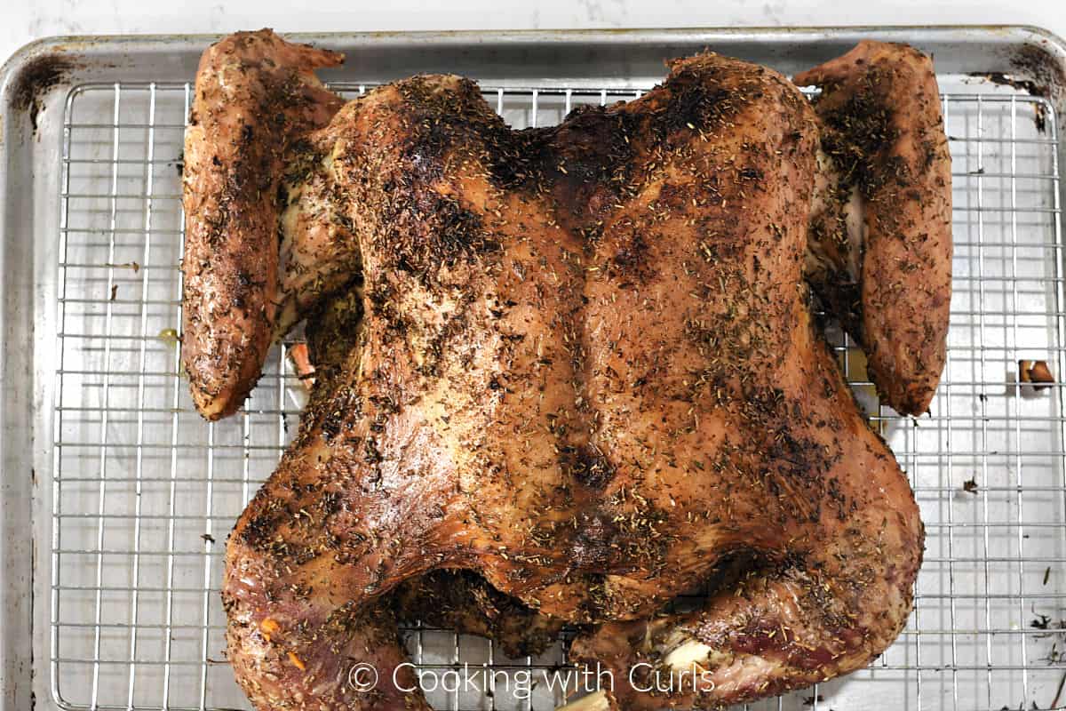 Roasted, butterflied turkey on a wire cooking rack over a baking sheet. 