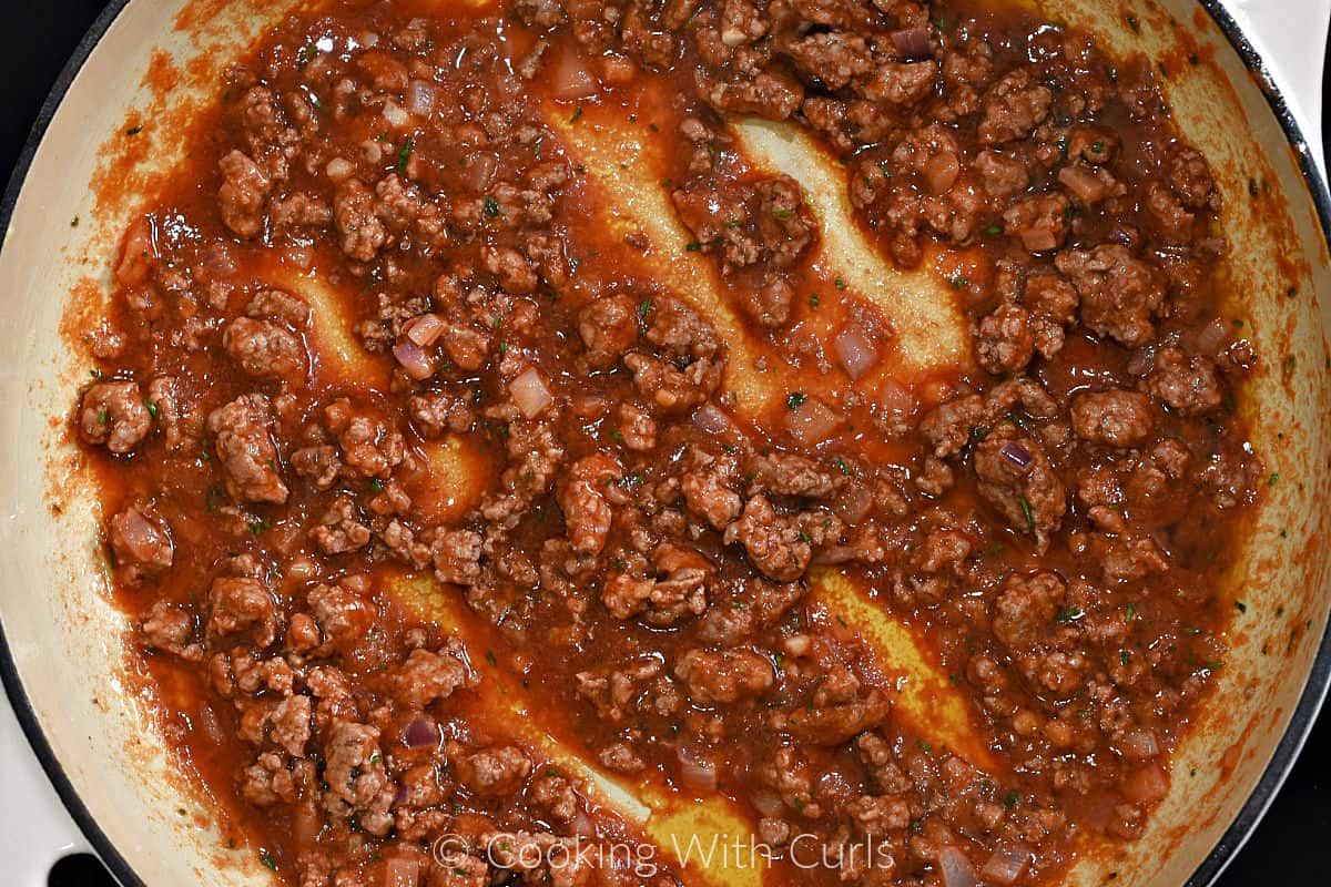 Tomato sauce and ground lamb in a large skillet. 
