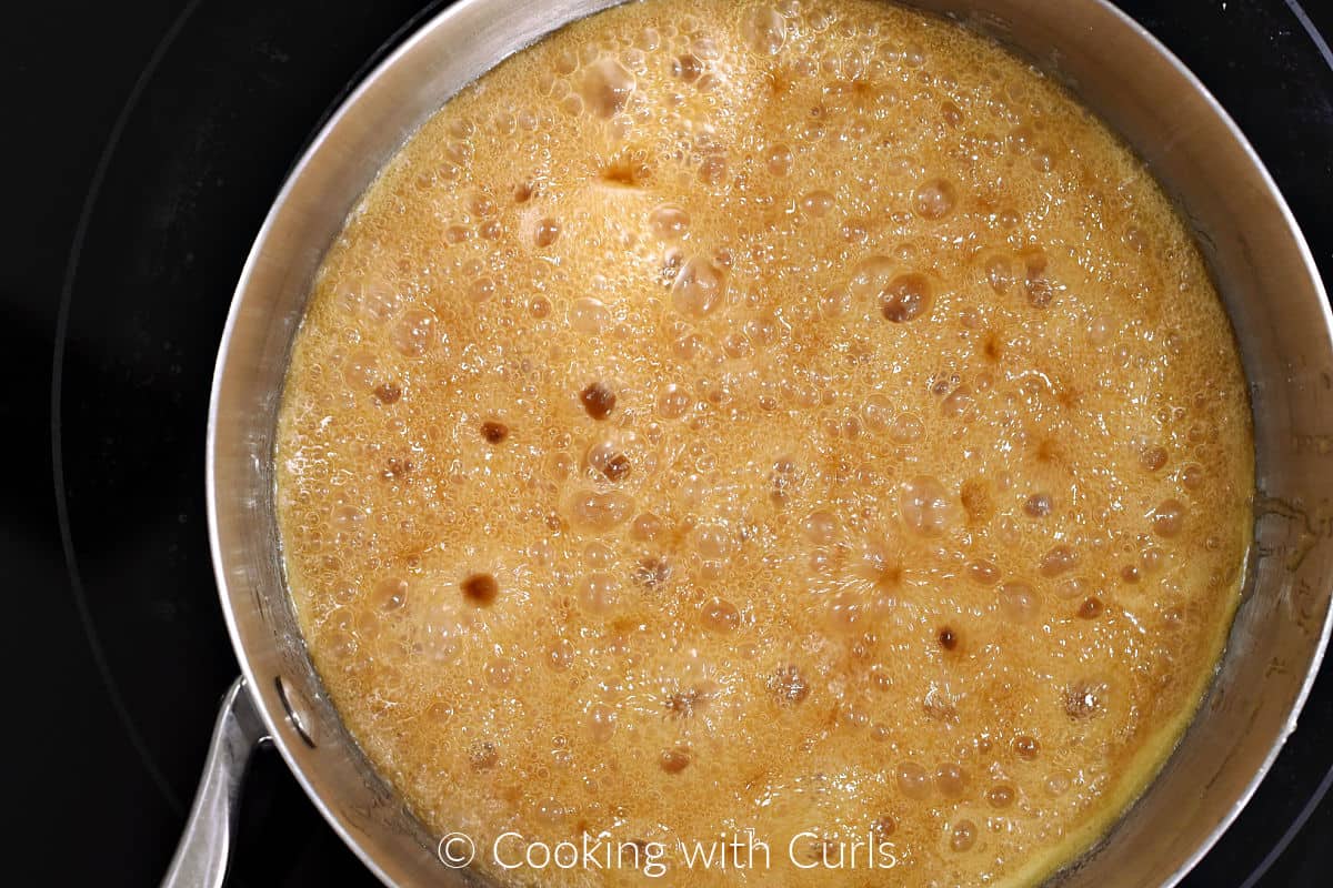 Caramel mixture boiling in a saucepan. 
