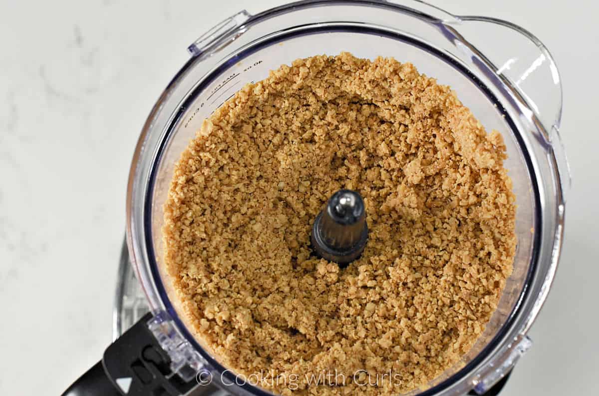 Course chopped peanuts in the bowl of a food processor. 