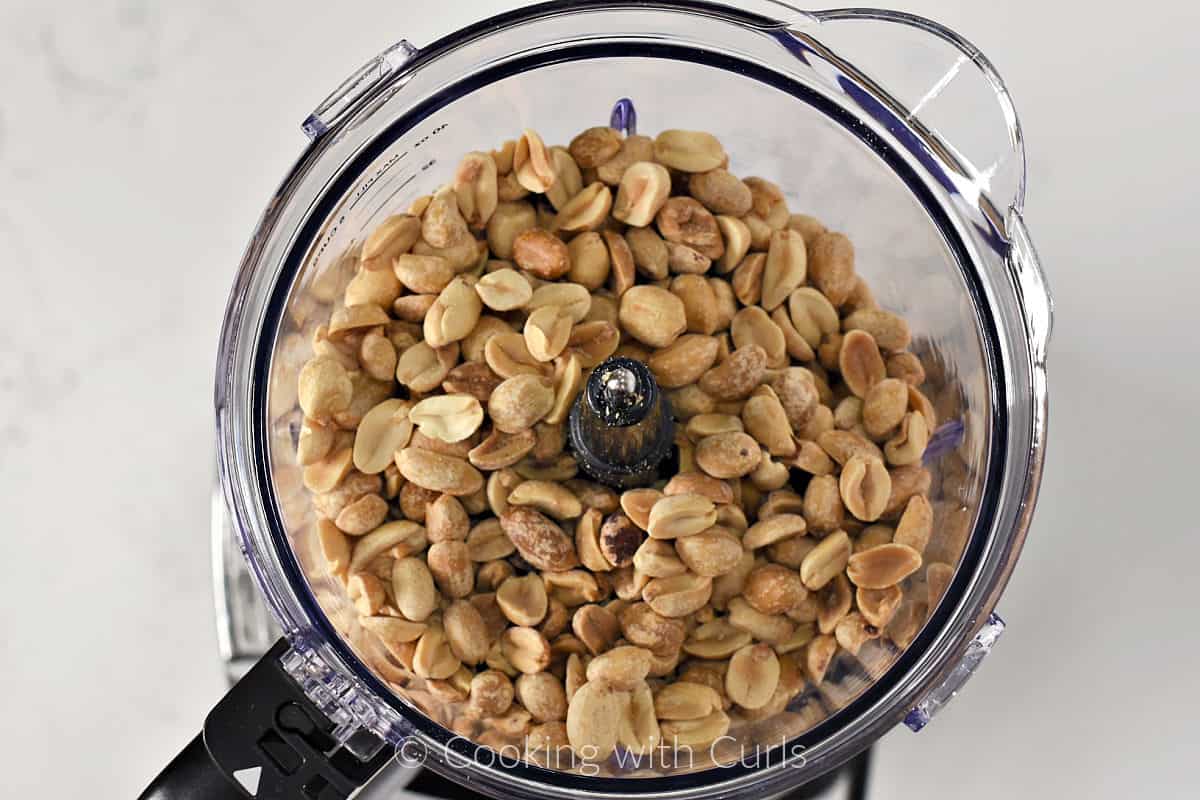 Dry roasted peanuts in the bowl of a food processor. 