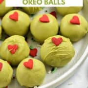 Thirteen green chocolate covered cookie balls with red candy hearts on a plate with title graphic across the top.