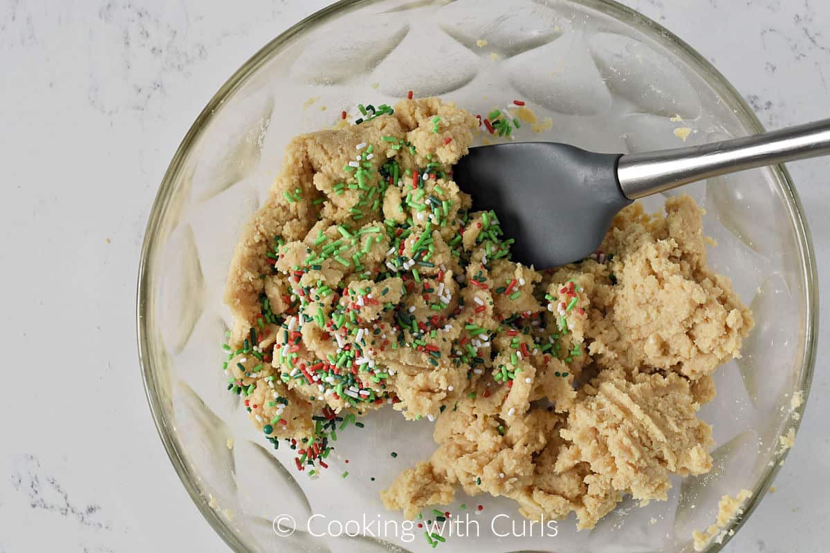 Holiday sprinkles mixed into the cookie mixture in a large bowl. 