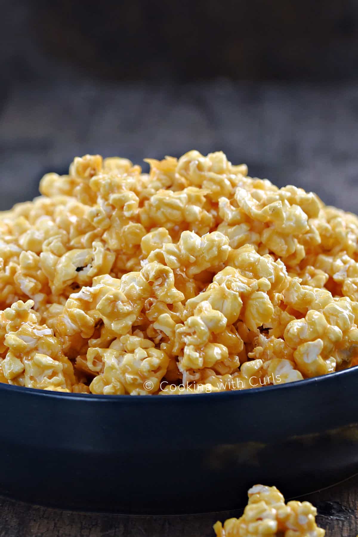 Side view of a blue bowl overflowing with honey lemon popcorn. 