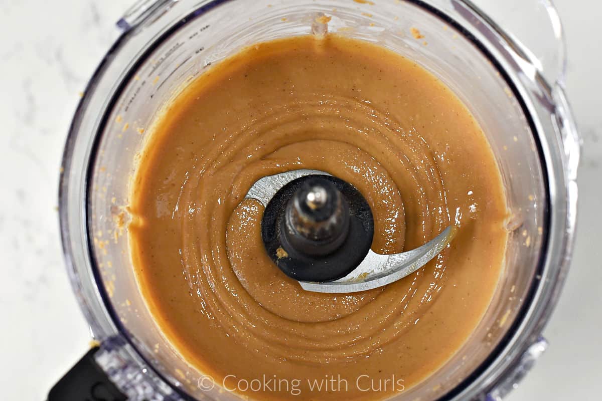Smooth homemade peanut butter in the bowl of a food processor. 