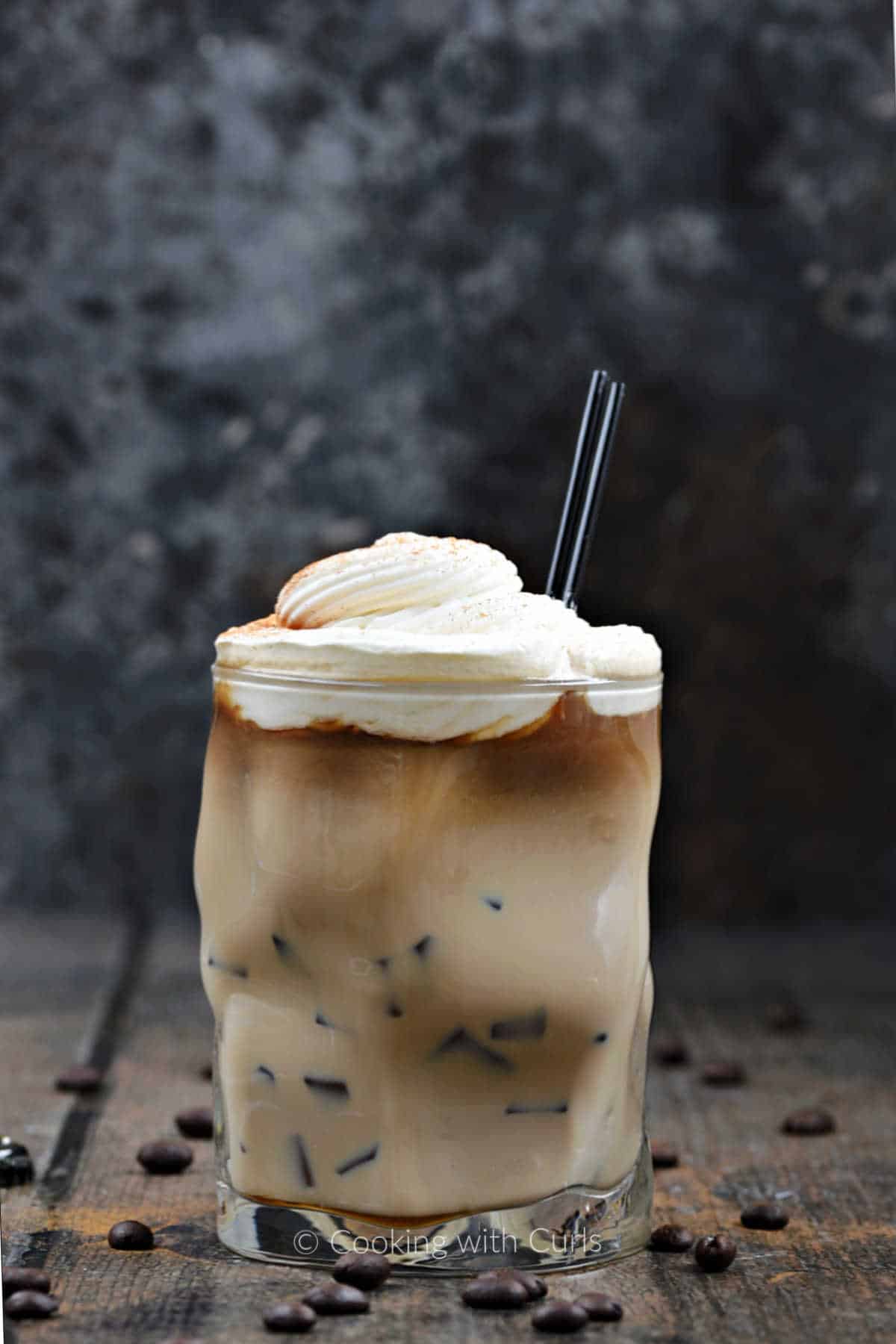 Irish Iced Coffee in a glass topped with whipped cream.