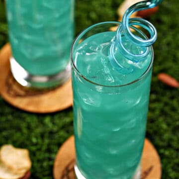 Looking down into a teal green Philadelphia eagles cocktail with spiral straw.