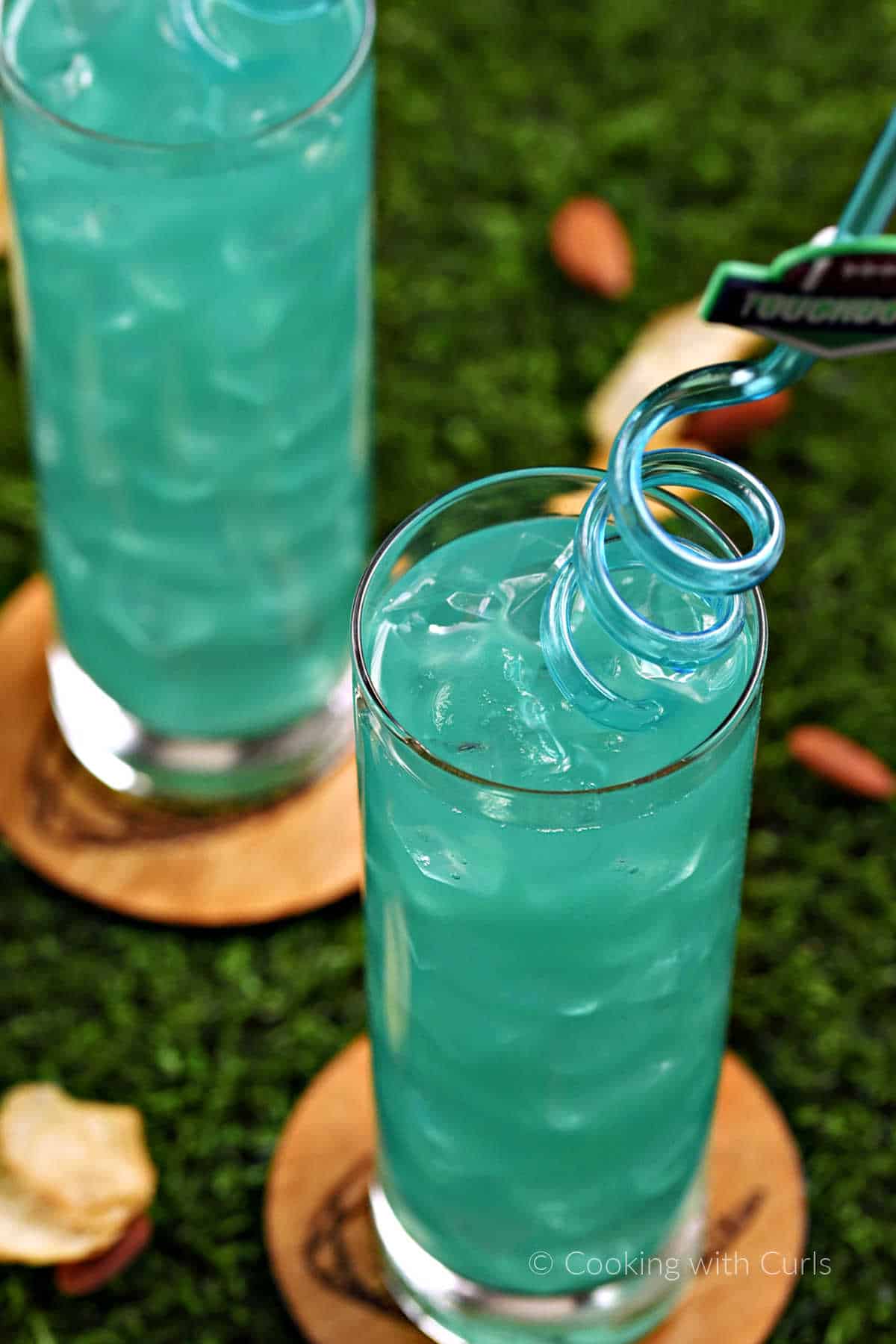 Looking down into a teal green Philadelphia eagles cocktail with spiral straw.