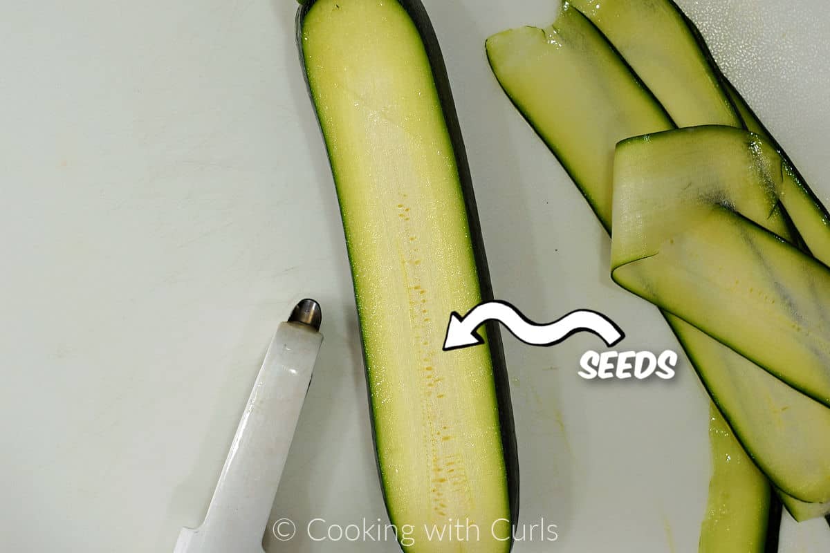 A zucchini with layers sliced off down to the seeds.
