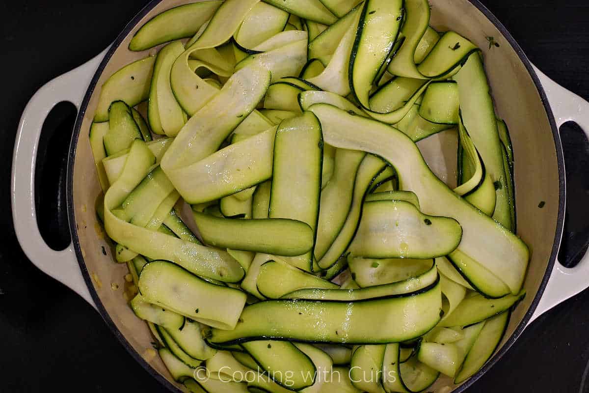 Zucchini ribbons tossed with herbed butter in a large skillet.