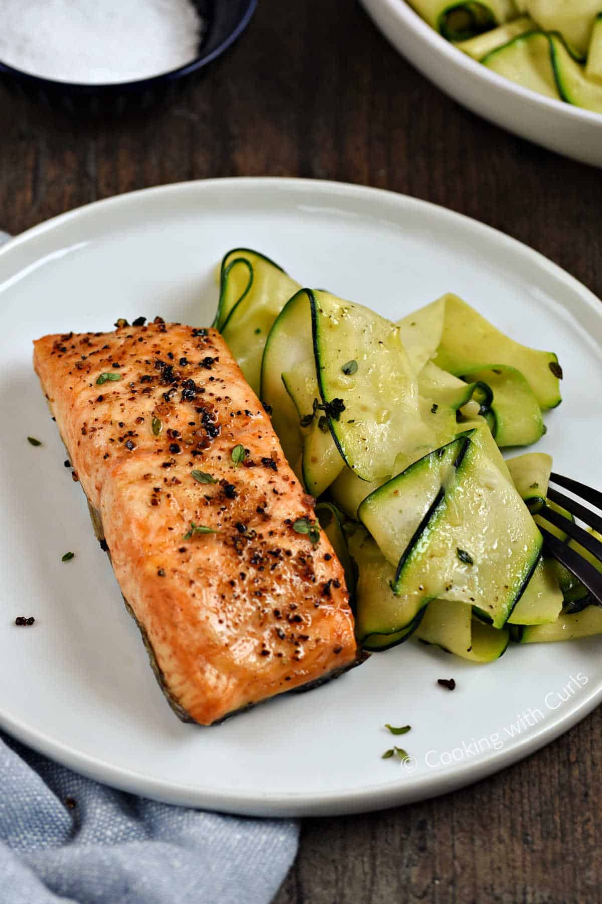 A salmon filet and sauteed zucchini ribbons on a plate.
