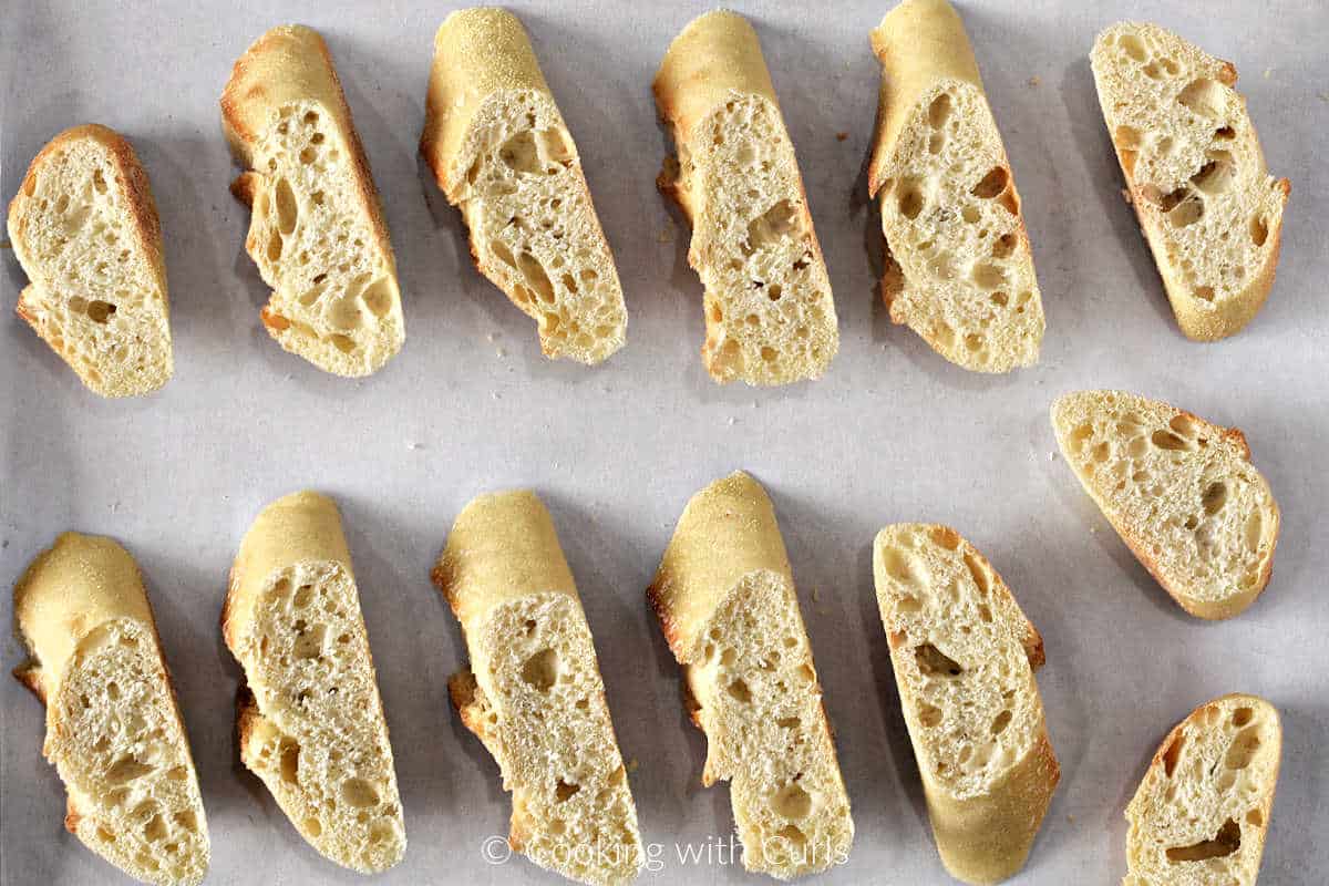 Thick bread slices on a parchment lined baking sheet.