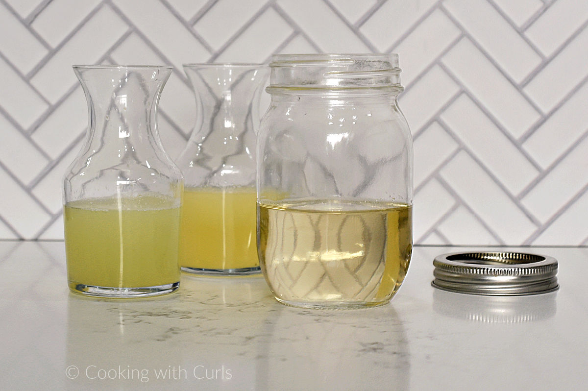 Simple syrup, lemon and lime juices in glass jars.