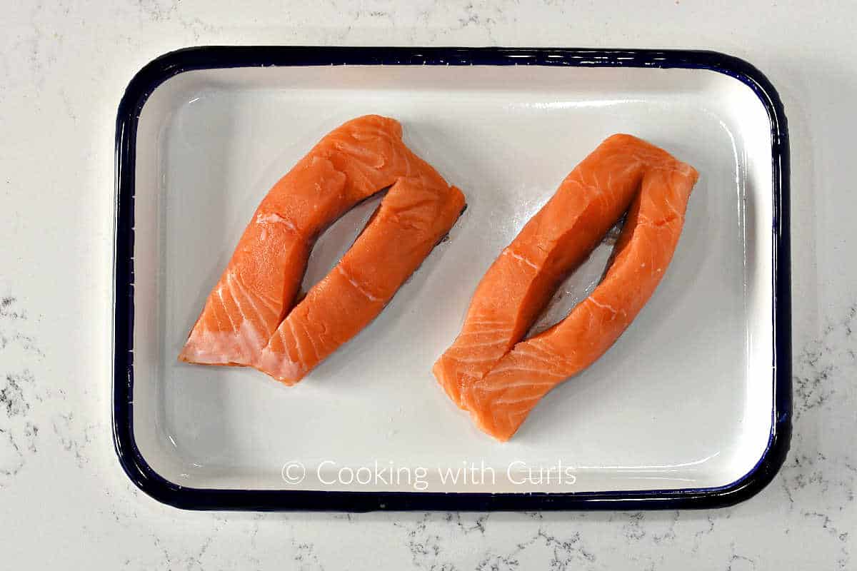 Two salmon fillets cut down the center to create an opening.