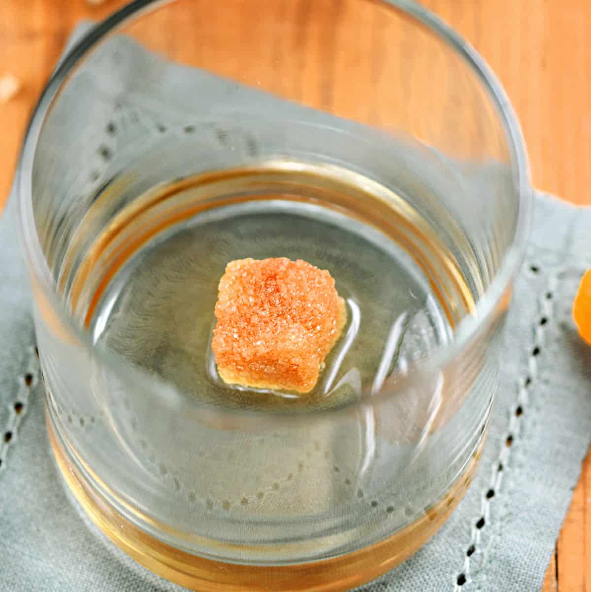 Sugar cube, bitters, and water in a rocks glass.