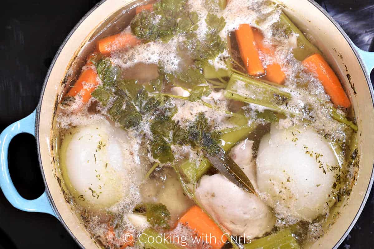 Cooked chicken and vegetables broth in a large pot.