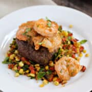 Beef tenderloin topped with tomato butter shrimp on grilled corn relish.
