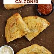 Two whole calzones and one cut in half on a board with pizza sauce in bowl and title graphic across the top.