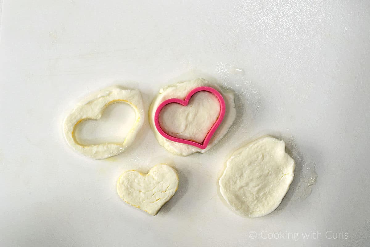 Fresh mozzarella slices cut into heart shapes with a small cookie cutter.
