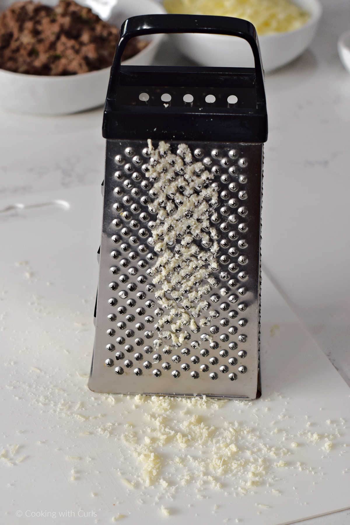 Parmesan cheese grated with  a boxed grater.