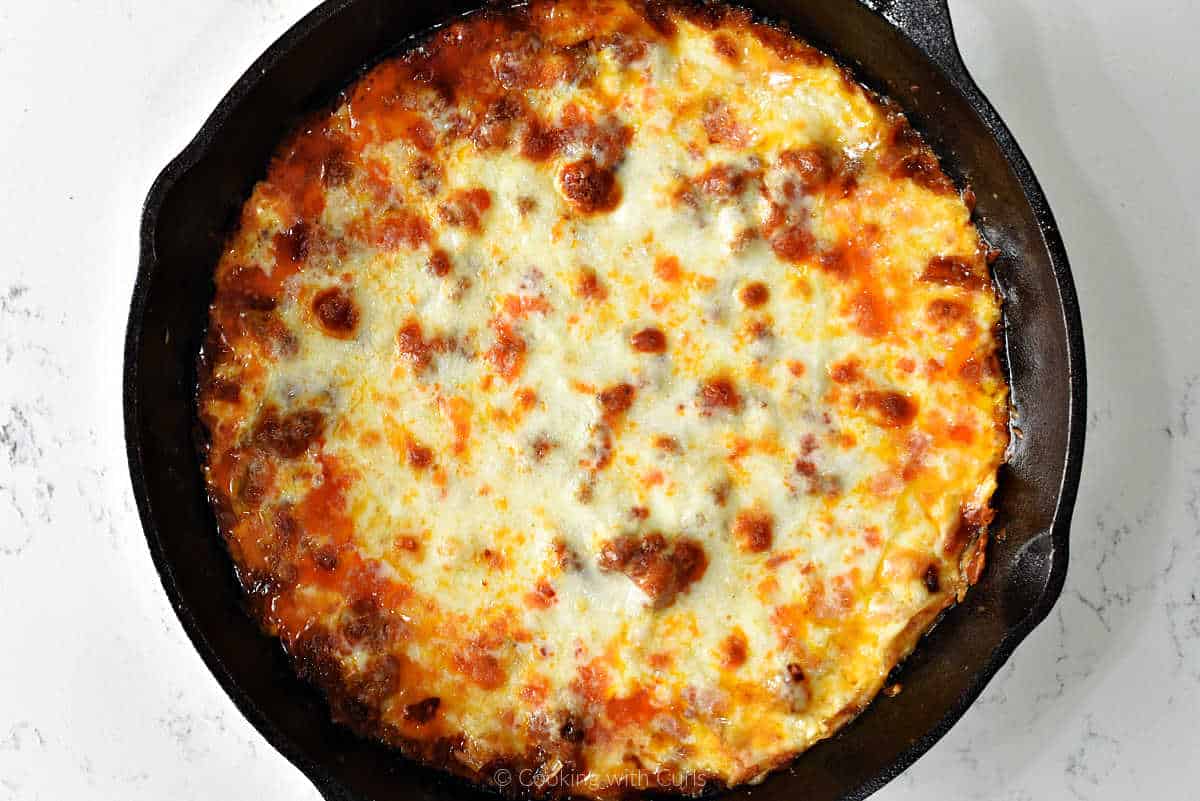 Bubbling queso fundido in cast iron skillet.